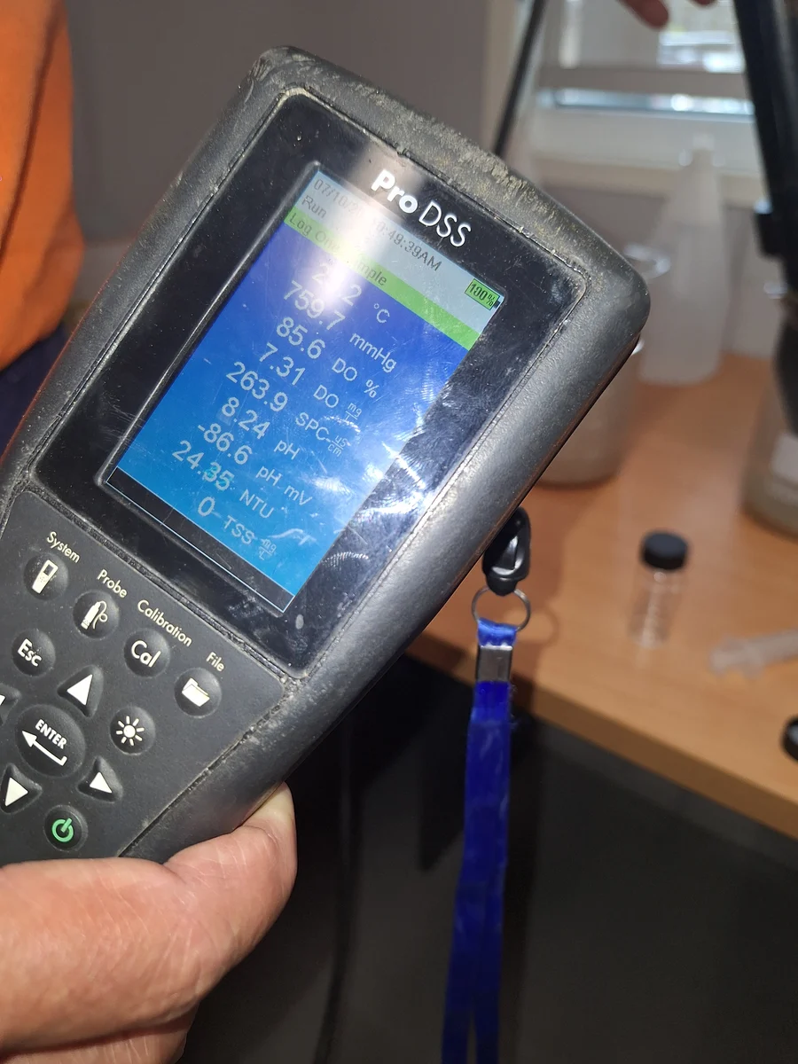 ProDSS meter photographed during HES Basin jar testing, displaying a turbidity reading below 26 NTU