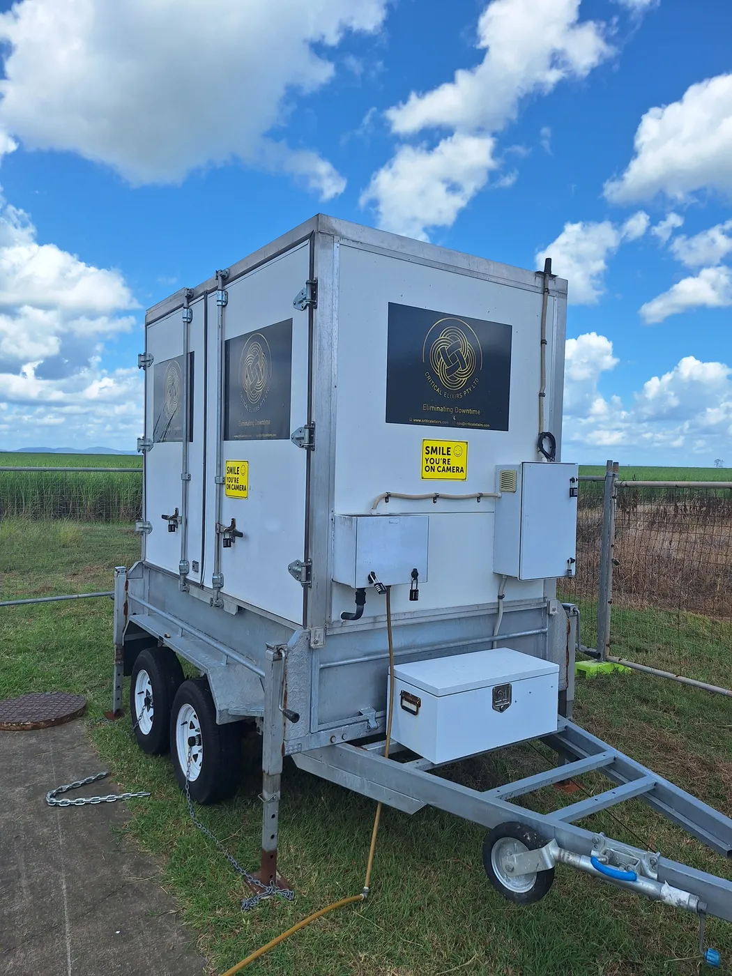Branded Critical Elixirs dosing trailer set up in the field with hoses connected